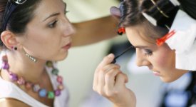 Makeup artist applying eye liner to client Photo
