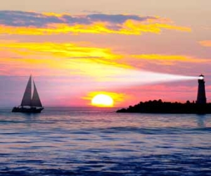 Lighthouse and Sailboat at Sunset Picture