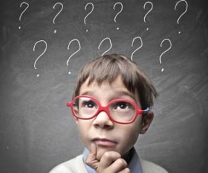 Child ponders the answer to question with question marks over head