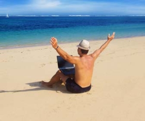 Man Sitting In Sand and Working On Laptap At The Beach Picture
