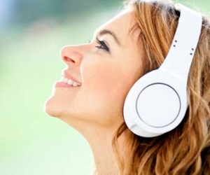 woman listening to podcast on headphones outside picture