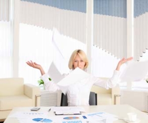 woman throwing papers in the air while at the office picture