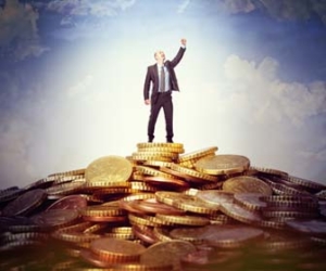 Triumphant man standing on top of pile of money image