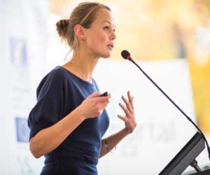 Business woman giving presentation in front of microphone