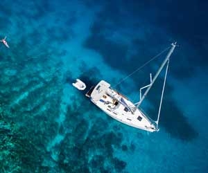 An aerial view of a luxury yacht in clear blue ocean waters