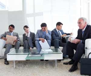 Five job seekers waiting on a sofa for a job interview