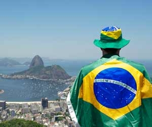 Man at Rio 2016 wrapped in Brazilian flag overlooking Rio de Janiero, Brazil