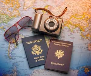 Travel Blogger planning trip with passports, camera, map, and sunglasses planning
