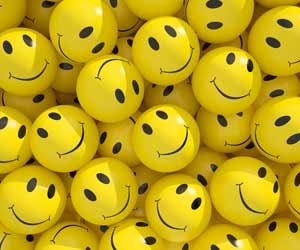 A collection of yellow balls with smiley faces on them.