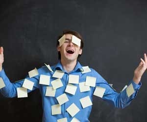 overwhelmed man covered in post-it notes