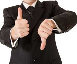 A businessman gives a thumbs up and a thumbs down while giving feedback