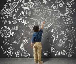 Child drawing futuristic concepts and skills on chalkboard