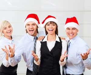 Four festive workers spread the holiday cheer at the office holiday party