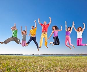 Happy people jumping in air in field