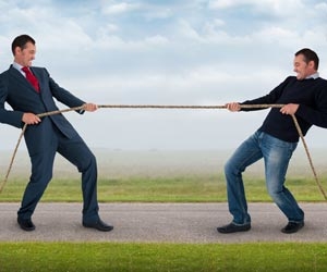 Businessman and contractor having tug of war with rope