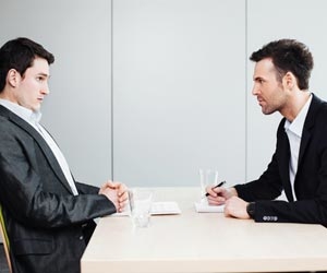 Recruiter staring across table at nervous job candidate