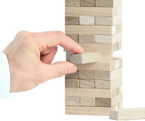 Hand pulling out blocks from stacking game