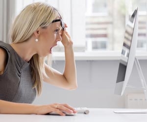 Frustrated job seeker screams at computer screen