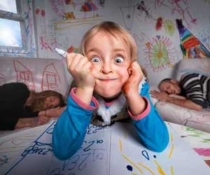 Girl making funny face after coloring entire house in marker while parents sleep