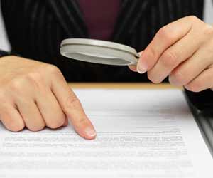 Paralegal scanning an employment contract with a magnifying glass