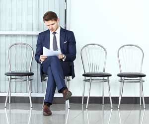 Lone job candidate sitting alone outside of job interview room