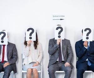 Job candidates waiting for job interview while holding question marks over face