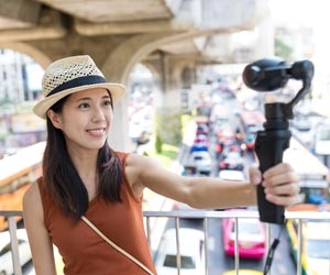 Female traveler making video in busy city scene
