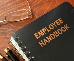 Employee handbook sitting on wooden desk