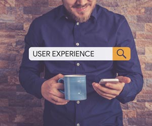 Man drinking coffee and searching for "user experience" on his smartphone