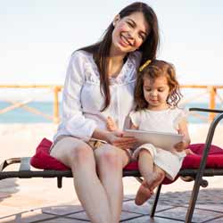 Au Pair Posing on Chair with Young Girl Photo