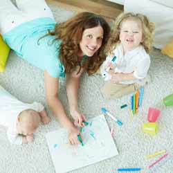 Nanny Drawing on Floor with Two Children Photo
