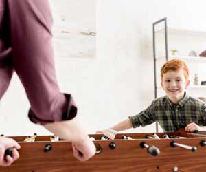 Male Nanny Playing Foosball with Child